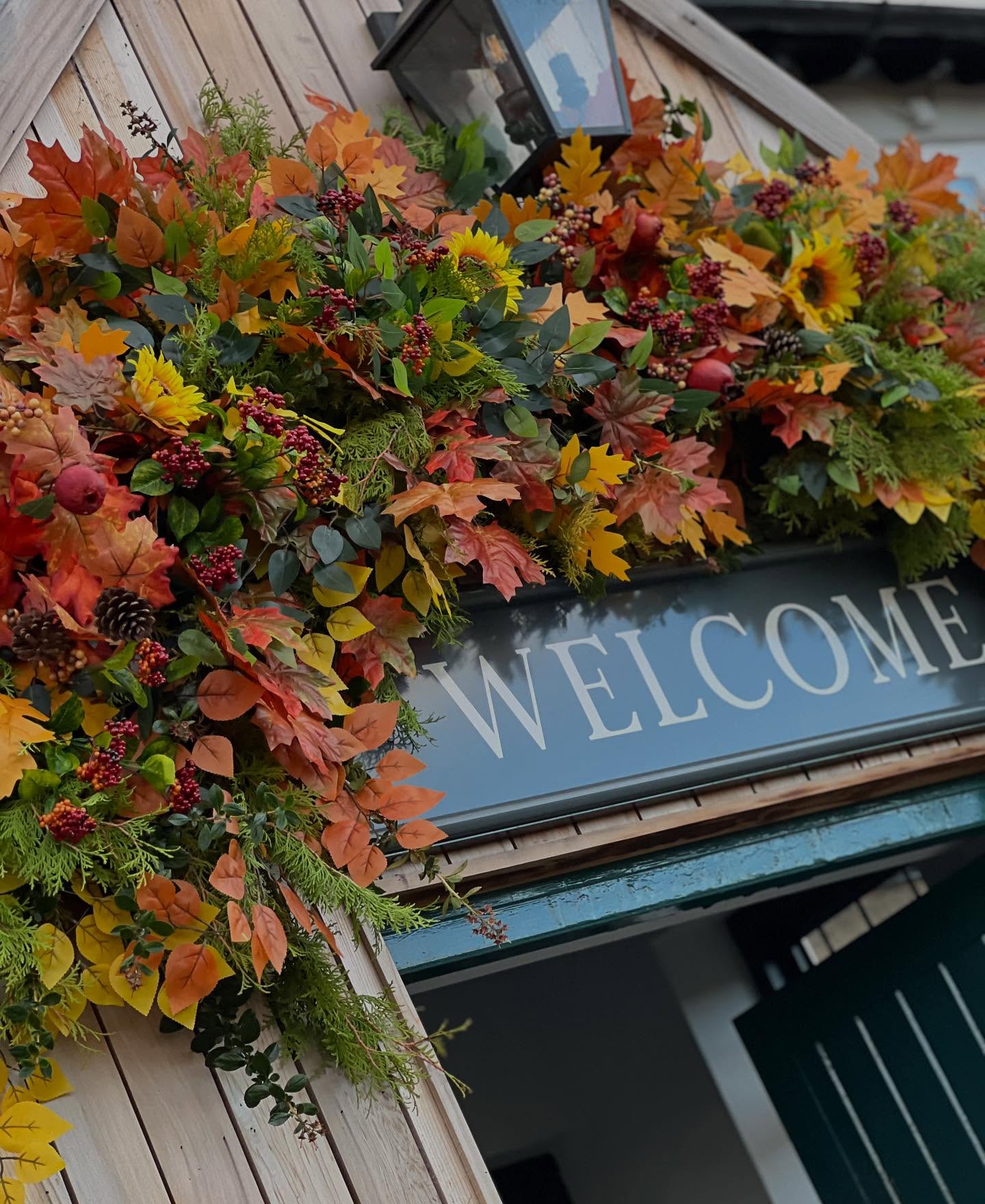 Orange foliage and sunflowers framing a shop entrance